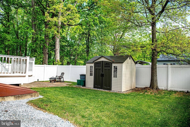 view of yard featuring a fenced backyard, an outbuilding, a shed, and a wooden deck