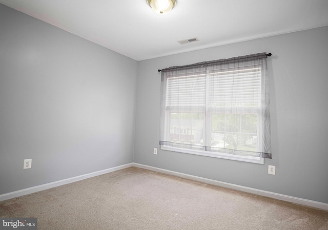 spare room with visible vents, carpet, and a healthy amount of sunlight