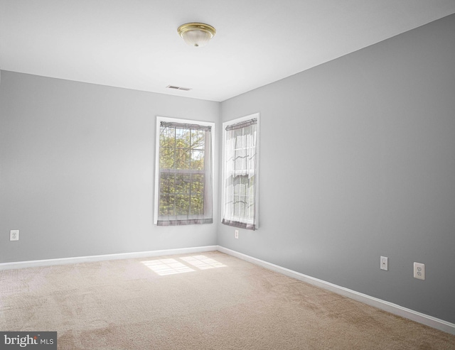 carpeted empty room with baseboards and visible vents