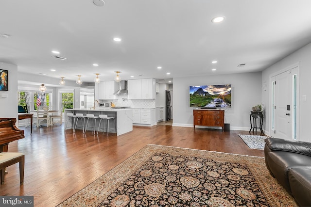 living area with baseboards, dark wood-type flooring, visible vents, and recessed lighting