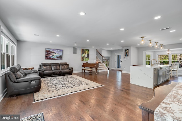 living room with baseboards, visible vents, recessed lighting, and stairway