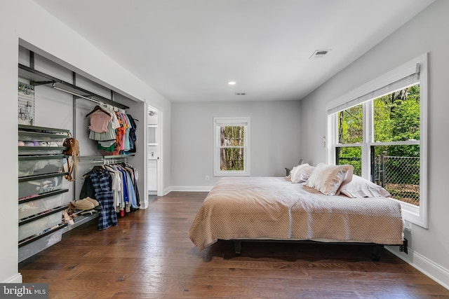 bedroom featuring wood finished floors, visible vents, baseboards, and multiple windows
