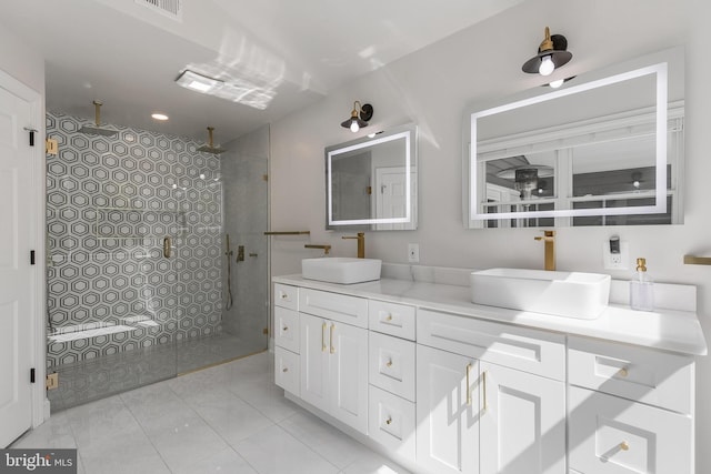 bathroom with visible vents, a sink, double vanity, and tiled shower