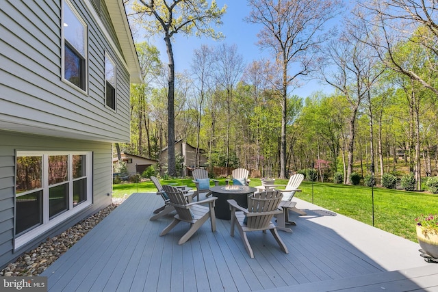 wooden terrace with a lawn and an outdoor fire pit