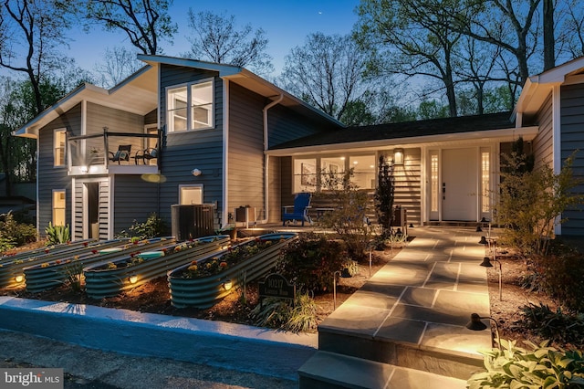 view of front of house featuring a balcony and a vegetable garden