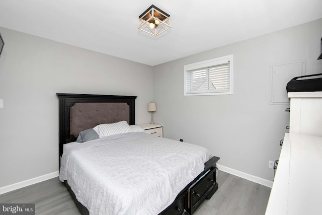 bedroom featuring light wood finished floors and baseboards
