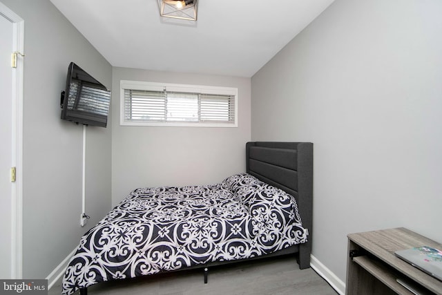 bedroom featuring baseboards and wood finished floors