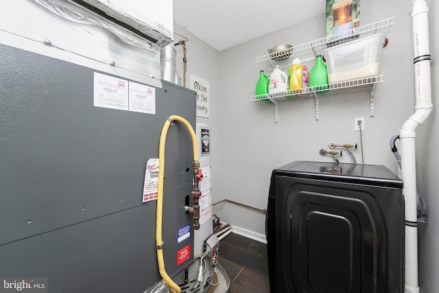 utility room featuring washing machine and clothes dryer and heating unit