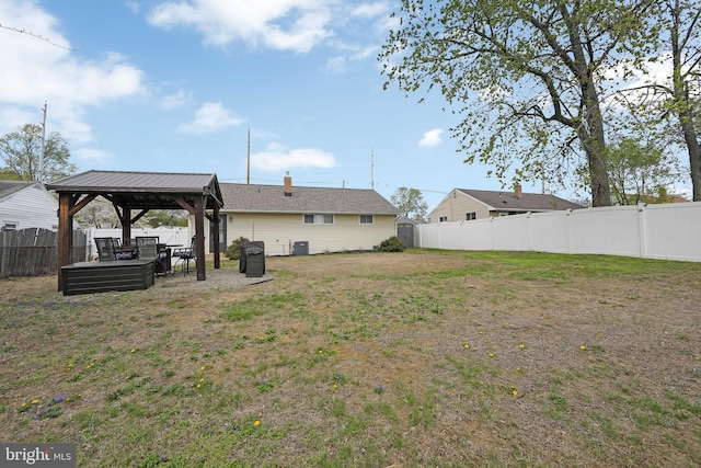 view of yard with a fenced backyard, a gazebo, and central air condition unit