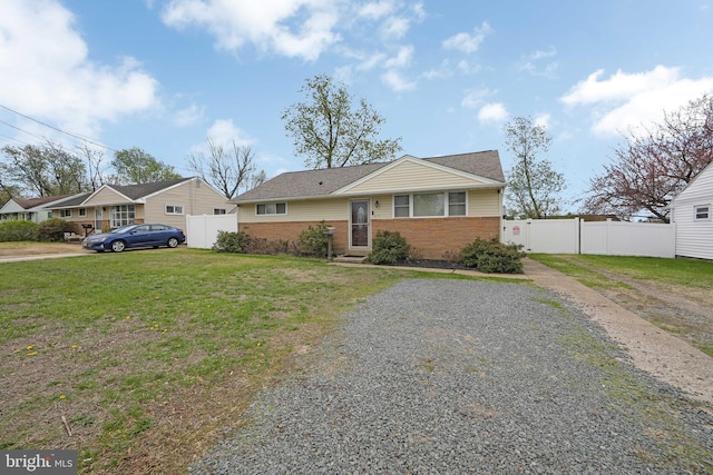bungalow-style house featuring brick siding, a front lawn, and fence
