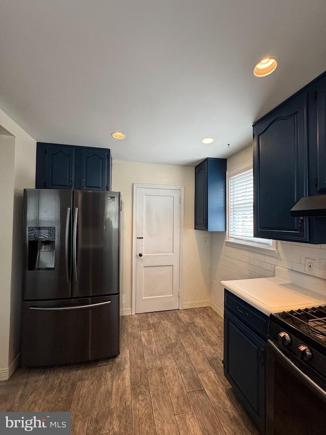 kitchen featuring dark wood-type flooring, baseboards, black gas range oven, and stainless steel fridge with ice dispenser