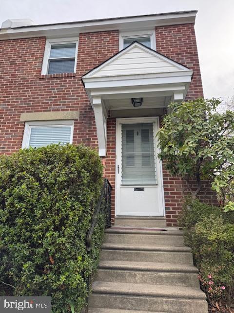 view of exterior entry with brick siding