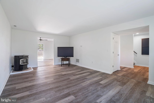 13217 Gundale, Middle River, MD 21220 - unfurnished living room with ceiling fan, visible vents, a wood stove, wood finished floors, and stairway