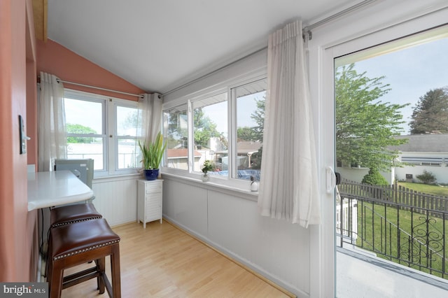 sunroom / solarium featuring wood finished floors and lofted ceiling