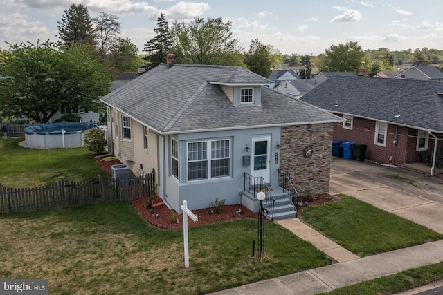 view of front of house featuring fence, a fenced in pool, a chimney, and a front yard