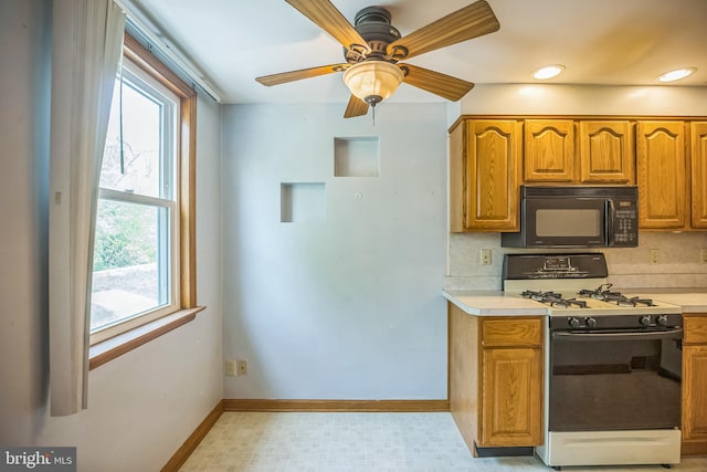 kitchen with light countertops, black microwave, a healthy amount of sunlight, and gas range oven