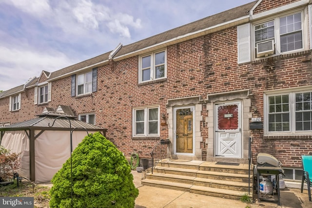 multi unit property with brick siding and a gazebo