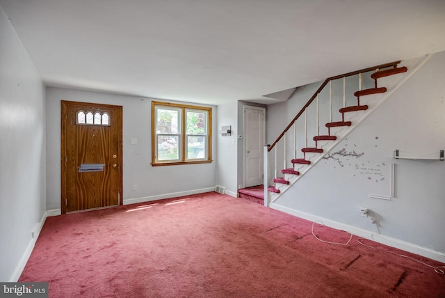 foyer entrance with baseboards, carpet flooring, stairs, and visible vents