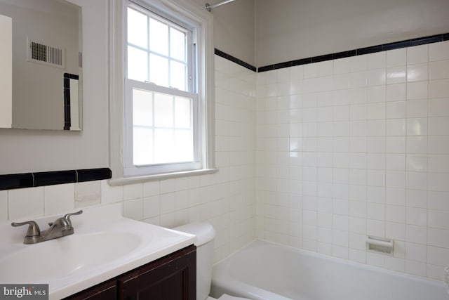 bathroom featuring toilet, visible vents, vanity, and shower / bath combination