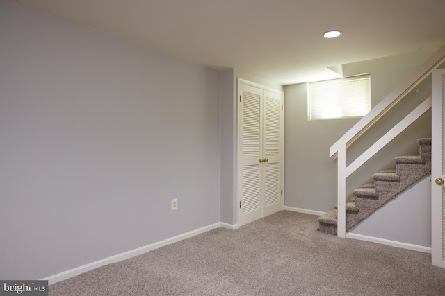 basement featuring baseboards, stairway, recessed lighting, and carpet