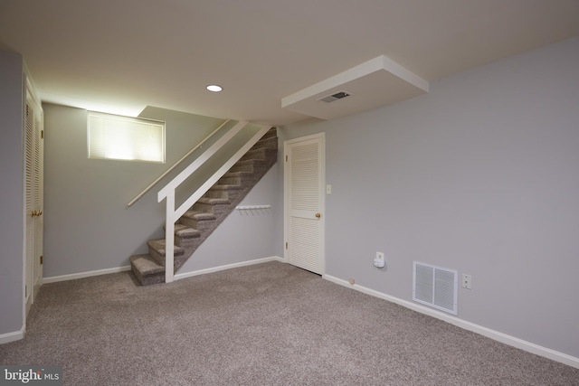 basement with carpet flooring, visible vents, baseboards, and stairs