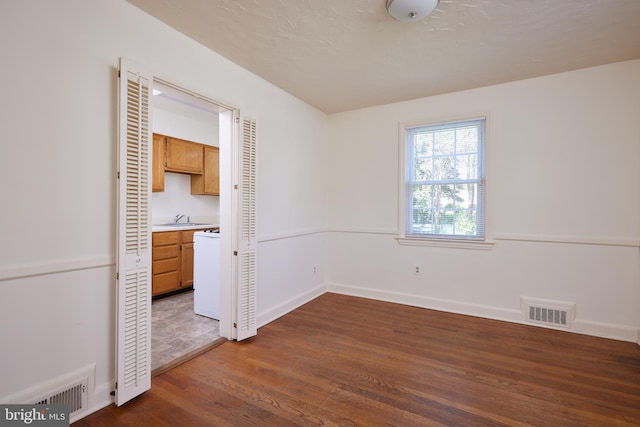 interior space with visible vents, baseboards, dark wood-type flooring, and a sink