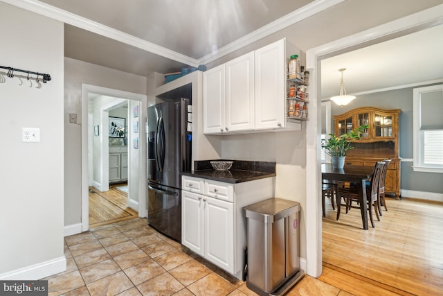 3330 Richmond Ave, Baltimore, MD 21213 - kitchen featuring stainless steel fridge with ice dispenser, white cabinetry, ornamental molding, baseboards, and dark stone countertops
