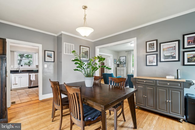 3330 Richmond Ave, Baltimore, MD 21213 - dining area with crown molding, light wood-style flooring, and baseboards