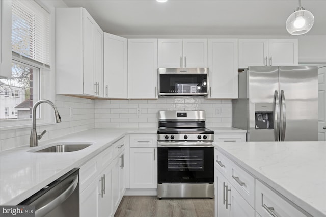 kitchen featuring white cabinets, stainless steel appliances, and a sink