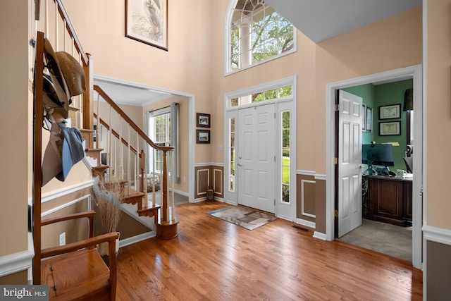 3211 Havenwood Ct, Edgewater, MD 21037 - entryway with stairway, wood finished floors, wainscoting, a towering ceiling, and a decorative wall