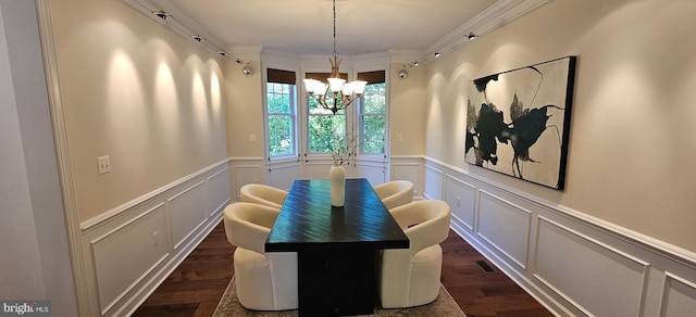 dining room with a decorative wall, dark wood-style flooring, an inviting chandelier, a wainscoted wall, and ornamental molding