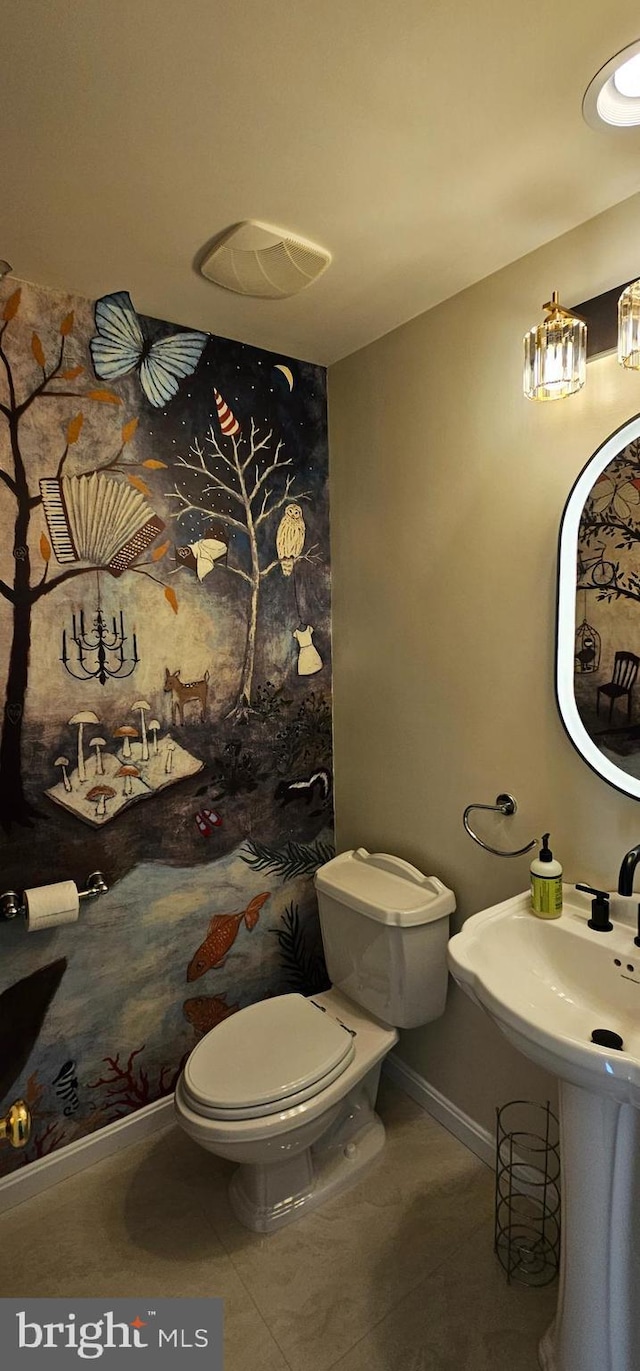 bathroom featuring toilet, tile patterned flooring, and baseboards