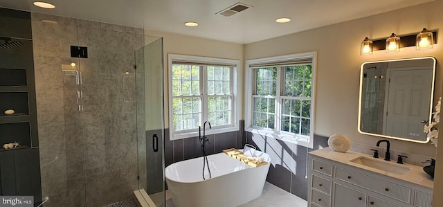 full bath with wainscoting, a freestanding tub, a stall shower, and plenty of natural light