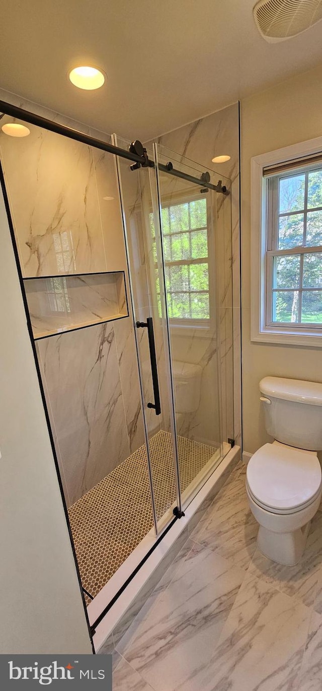 full bathroom with visible vents, marble finish floor, a marble finish shower, and toilet