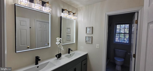bathroom featuring a sink, double vanity, and toilet