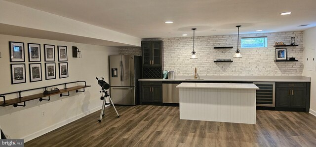 kitchen with beverage cooler, stainless steel appliances, dark wood-style floors, and light countertops