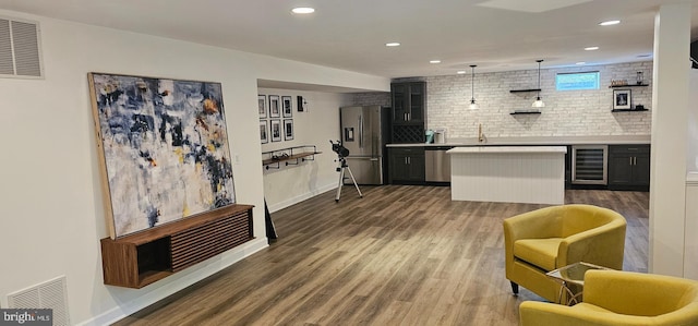 kitchen featuring dark wood finished floors, visible vents, stainless steel appliances, and wine cooler