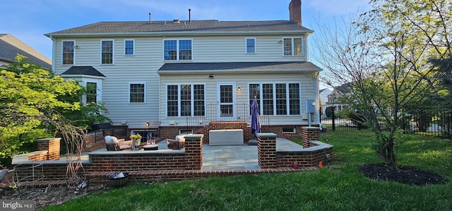 rear view of property featuring a chimney, fence, entry steps, a patio area, and a lawn