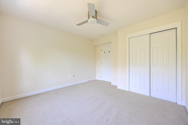 unfurnished bedroom with light colored carpet, ceiling fan, a closet, and baseboards