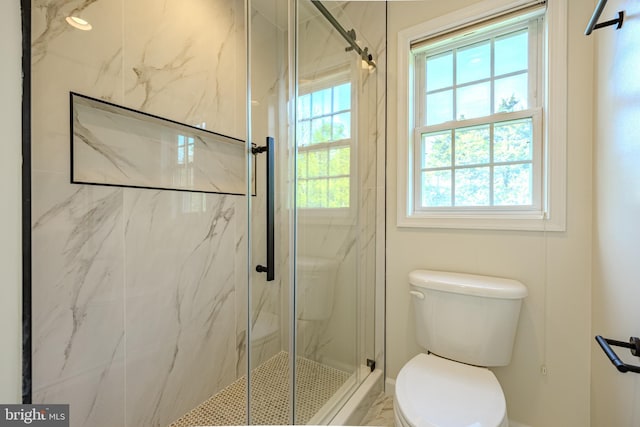 full bathroom featuring a healthy amount of sunlight, a marble finish shower, and toilet