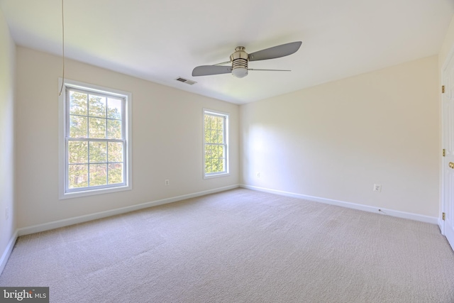 empty room featuring baseboards, visible vents, light carpet, and a healthy amount of sunlight