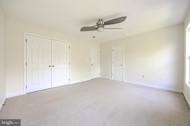 unfurnished bedroom featuring attic access, light colored carpet, and baseboards