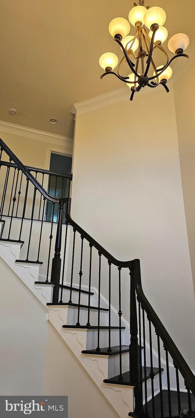 staircase featuring crown molding and a notable chandelier