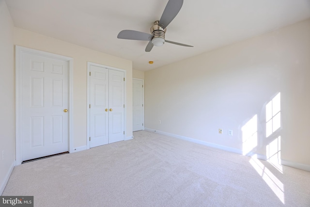 unfurnished bedroom featuring baseboards, a ceiling fan, a closet, and carpet