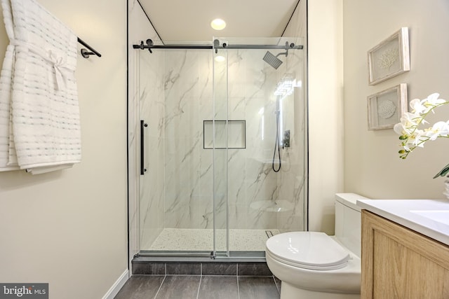 bathroom featuring baseboards, a marble finish shower, toilet, and vanity