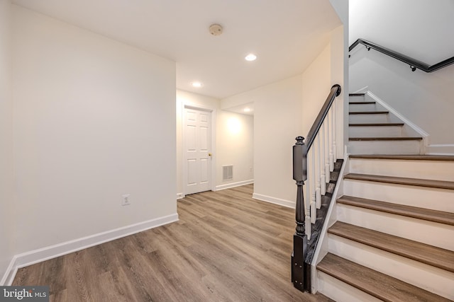 stairs with baseboards, visible vents, wood finished floors, and recessed lighting