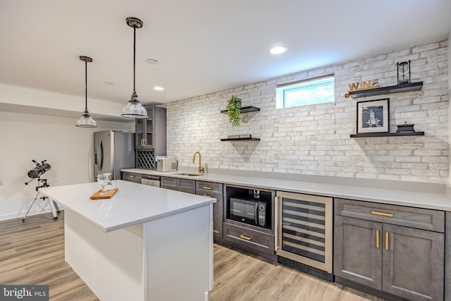 kitchen featuring stainless steel appliances, open shelves, light countertops, a sink, and wine cooler