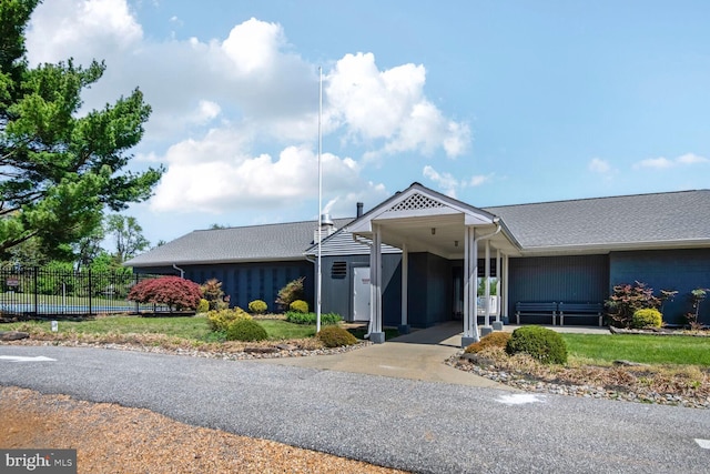 view of front of property with fence and roof with shingles