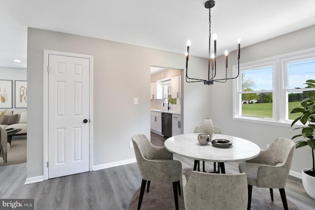 dining room with an inviting chandelier, baseboards, and wood finished floors