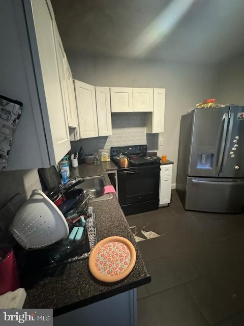1341 E Rittenhouse St, Philadelphia, PA 19138 - kitchen featuring black electric range oven, dark countertops, white cabinets, and stainless steel fridge